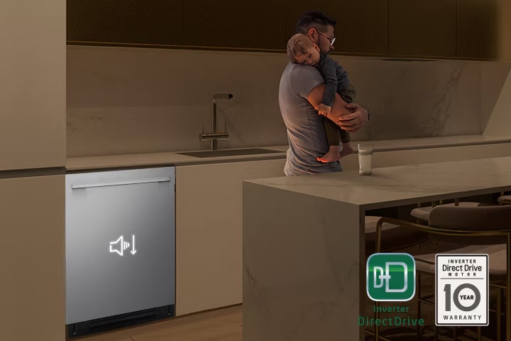 Man holding a sleeping child while a quiet dishwasher runs in the background