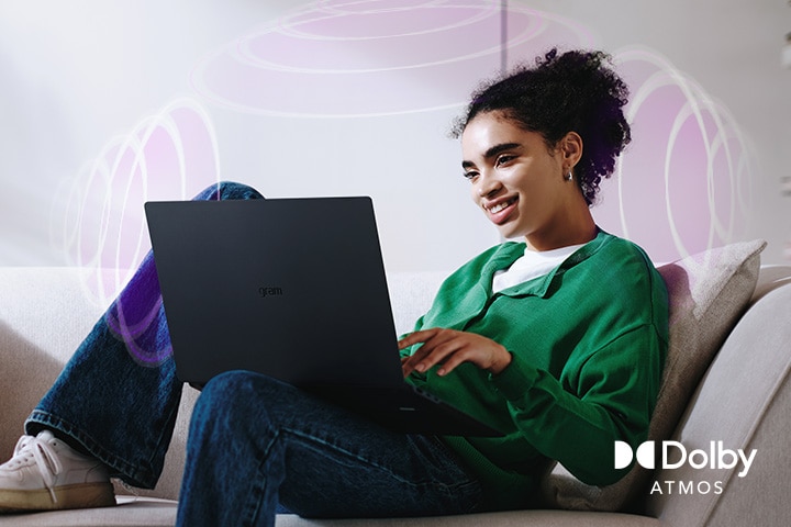 A person sitting on a couch, enjoying immersive audio while using an LG gram laptop. The text highlights Dolby Atmos technology, emphasizing a rich, expansive, 360-degree auditory experience. Surrounding sound waves in the background visually represent the immersive soundscape.