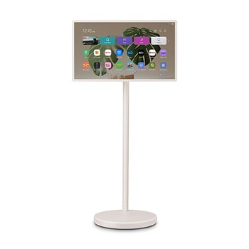 LG StanbyME 2 screens displayed in a modern living room. There is a StanbyME 2 on a stand, one is hung on the wall, and the other is propped up on a table using the folio cover.