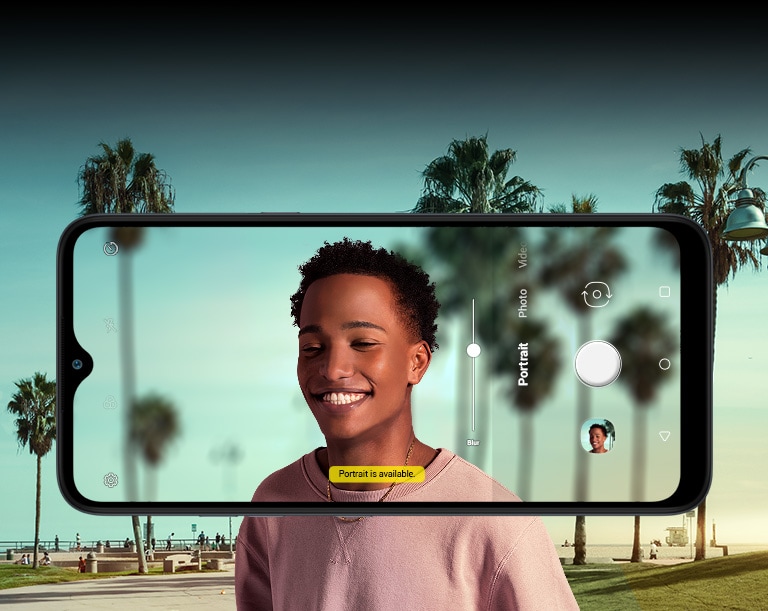 Man taking a selfie with palm tree behind