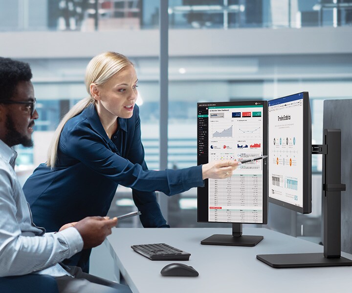 Two male and female employees discuss while looking at the monitor in the office.