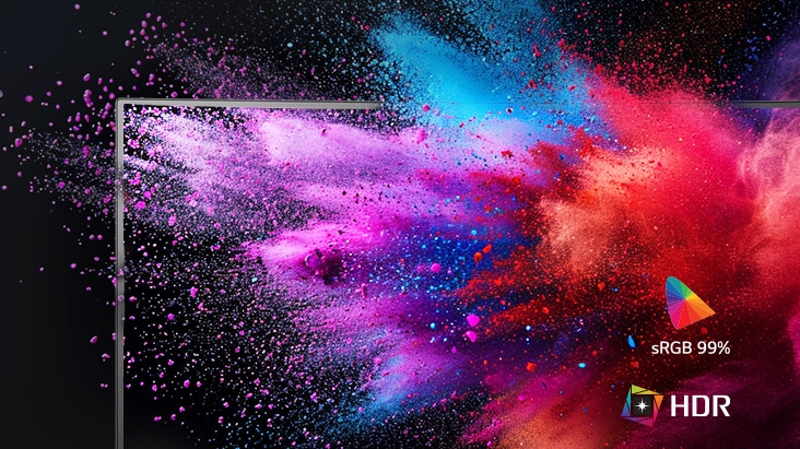 A monitor screen displaying a vivid explosion of coloured powder in pink, purple, blue, and orange tones, emphasizing colour performance. Icons on the right indicate sRGB 99% colour gamut and HDR support.