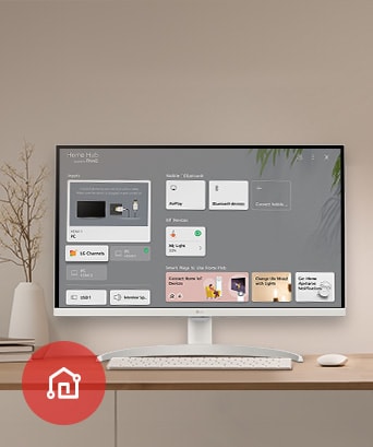 On the table, the monitor displays the Home dashboard screen, with the LG ThinQ App icon visible in the bottom left corner.