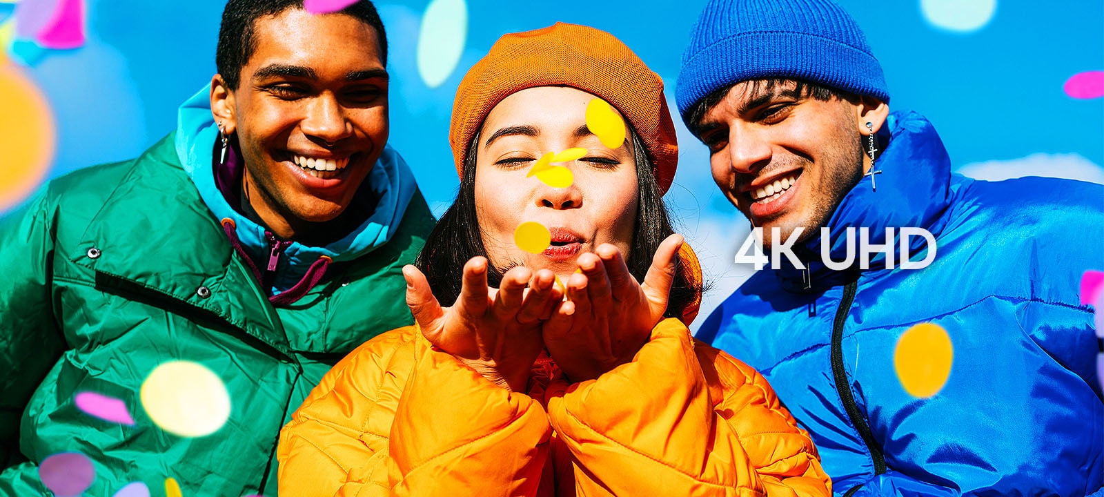 Three people wearing green, yellow, and blue outfits.