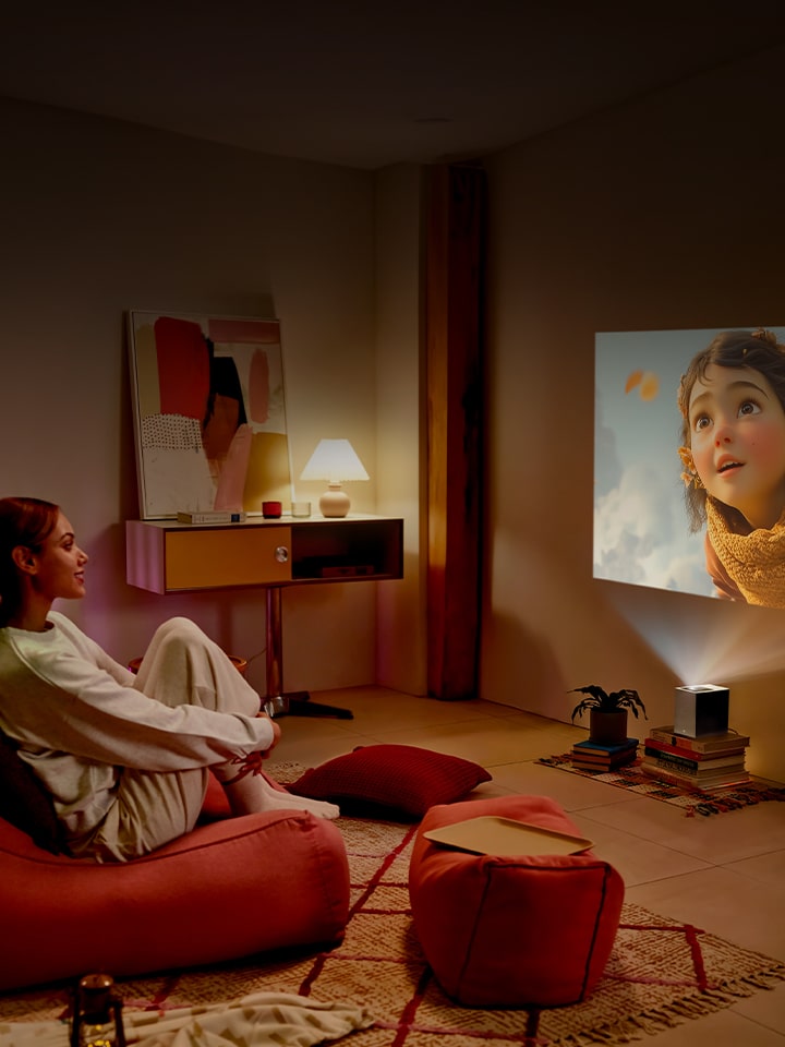 Woman watching a movie with LG CineBeam.