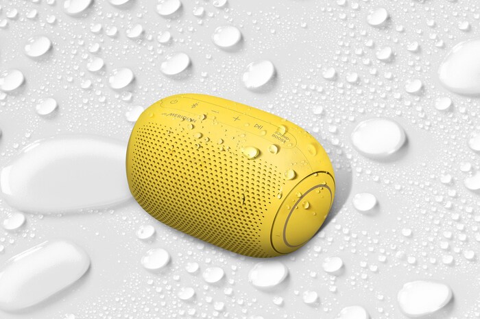 A top view of an LG XBOOM Go on a white surface with water droplets