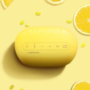 Lemons, jellybeans, and an LG XBOOM Go PL2S are placed on a yellow background.