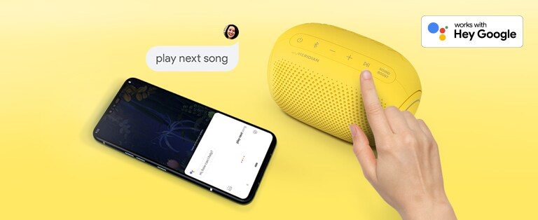 A top view of a finger pressing a button on an LG XBOOM Go PL2B and a smartphone lying next to it with a speech bubble and a Google logo