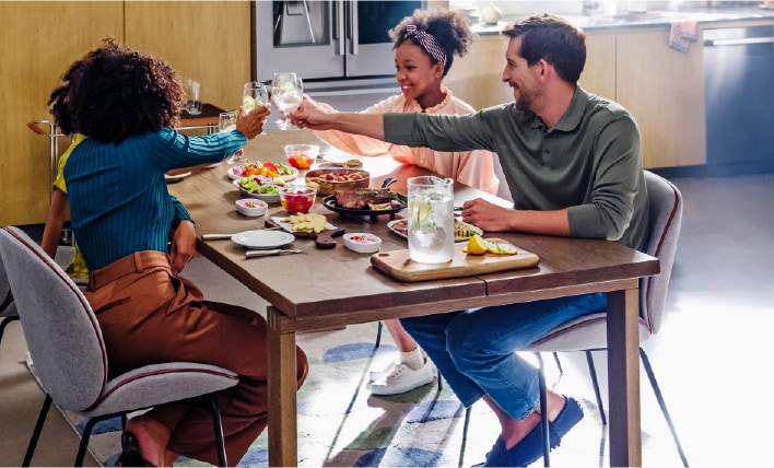Family gathered around a dining table in a modern kitchen