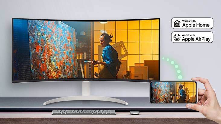 On the table, there is a monitor displaying a scene from a movie, and the same scene is displayed on a mobile device placed to the bottom right.	