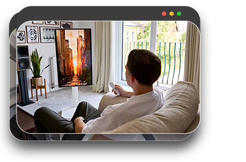 Man relaxing on sofa, watching content on a monitor screen in a comfortable living space.