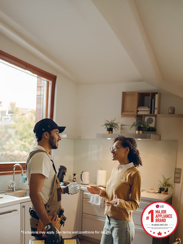 Installer discusses repairs with customer in the kitchen