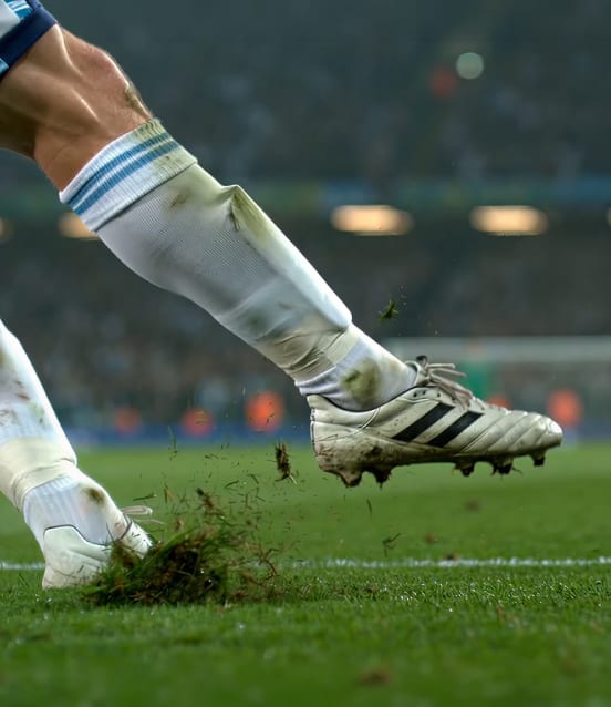 Joueur de football frappant un ballon sur un terrain gazonné pendant un match