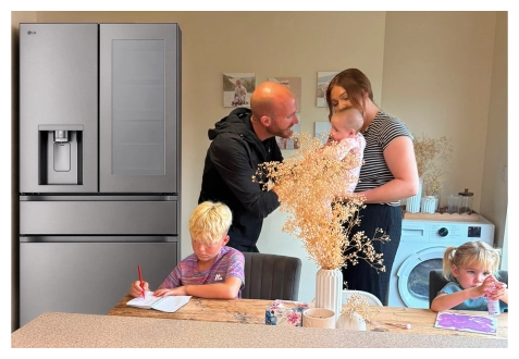 Une famille se réunit dans la cuisine près d’un réfrigérateur en acier inoxydable : un garçon dessine à table, une fille peint sur le plan de travail, tandis que les parents se tiennent ensemble en tenant un bébé.