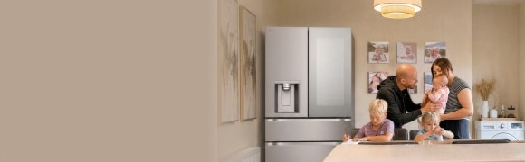Une famille se réunit dans une cuisine moderne, avec deux adultes et trois enfants près d’un réfrigérateur à portes françaises en acier inoxydable.