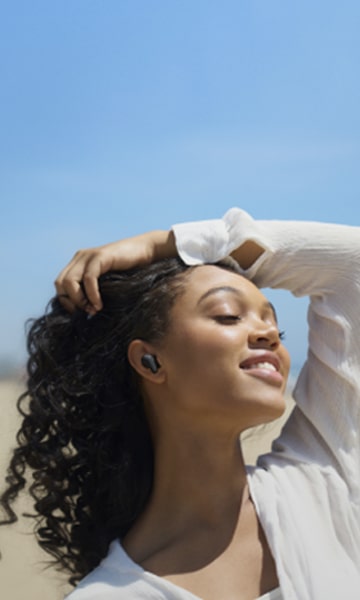 Une femme écoute de la musique avec les LG TONE Free