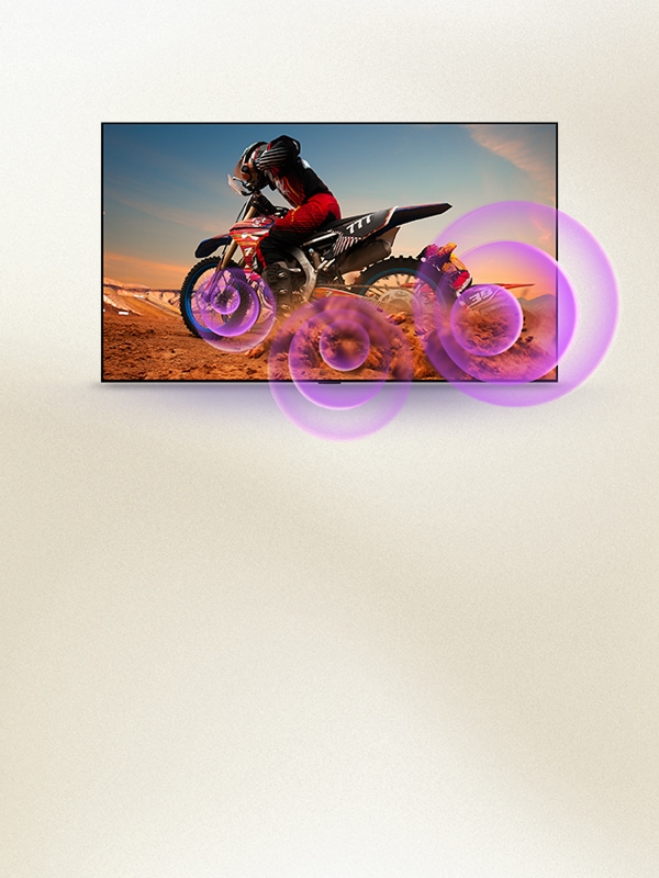 Image LG TV avec ondes sonores violettes autour d'un motard, illustrant le son riche du Dynamic Sound Booster.