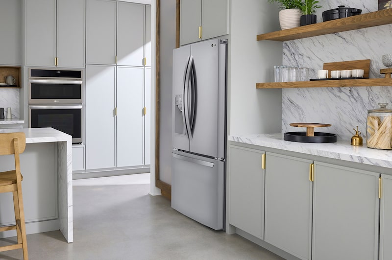 Le réfrigérateur à portes françaises LG LRFS28XBS de 36 po et 28 pi³ en acier inoxydable PrintProof™ avec distributeur de glace et d'eau, présenté dans une cuisine moderne et lumineuse.