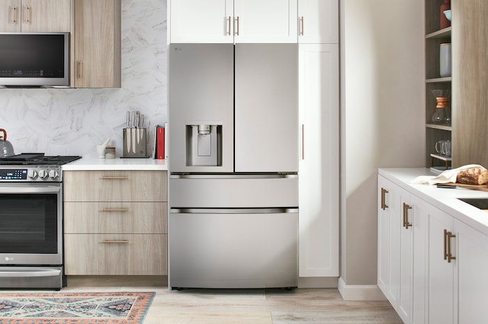 Le réfrigérateur à 4 portes françaises LG LF29S8330S de 36 po et 29 pi³ en acier inoxydable PrintProof™ avec distributeur de glace et d'eau, présenté dans une cuisine moderne.