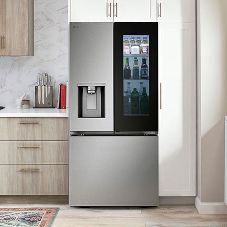 Le réfrigérateur à portes françaises LG LF25S6560S de 33 po et 25 pi³ en acier inoxydable PrintProof™ avec InstaView® Porte dans la porte® et distributeur de glace et d'eau, dans une cuisine moderne.