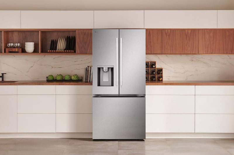 Le réfrigérateur à portes françaises LG LF25H6330S de 33 po et 25 pi³ en acier inoxydable PrintProof™ avec distributeur de glace et d'eau, présenté dans une cuisine moderne.
