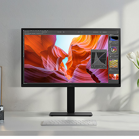 Moniteur LG 27BA45U en finition noir mat, avec gamut de couleur DCI-P3 90%, utilisé pour la retouche photo professionnelle et le design dans un studio élégant.