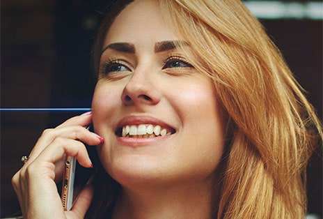 De gauche à droite : Une femme parle au téléphone à l’extérieur et porte les écouteurs T80S. Ils filtrent les bruits de fond et l’autre femme ne peut entendre clairement que sa voix.