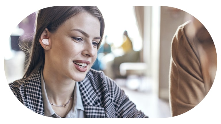 Une femme porte les écouteurs T80S et utilise le mode conversation.