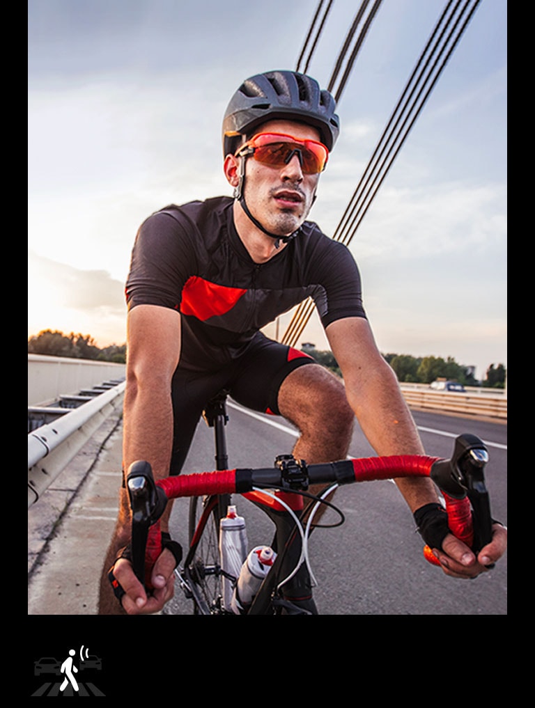 Un homme portant des écouteurs TONE Free fit fait du vélo.