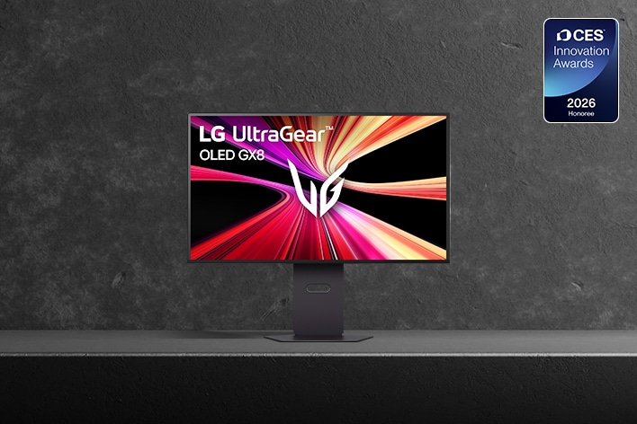 Le moniteur de jeu LG UltraGear™ 32GX870B est présenté sur une surface sombre à texture de pierre. L’écran affiche un graphisme dynamique de traînées lumineuses rouges, roses et jaunes avec le logo UltraGear au centre. Un badge « CES 2026 Innovation Awards Honoree » apparaît dans le coin supérieur droit.