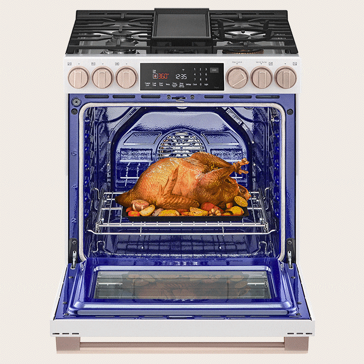 Cuisinière blanche avec four ouvert révélant un intérieur bleu vif et une dinde rôtie sur la grille.