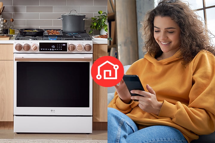 Femme souriante utilisant son smartphone à côté d'une cuisinière LG blanche avec des boutons dorés.