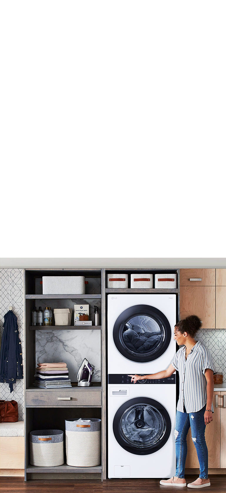 Femme interagit avec une laveuse-sécheuse LG, intégrée dans un espace buanderie moderne et bien organisé.