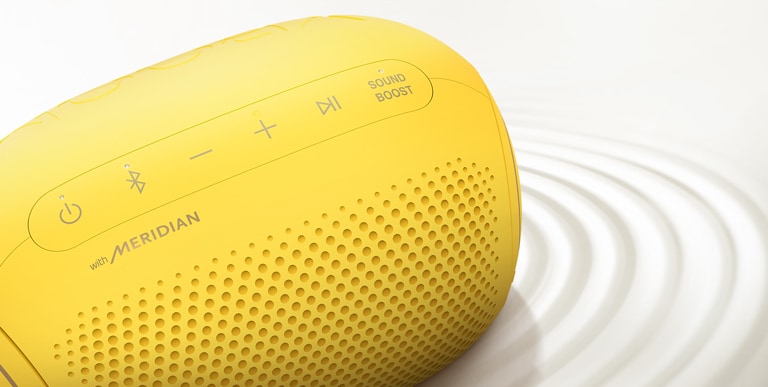 Vue de dessus d’un XBOOM Go PL2S de LG sur une surface blanche avec un effet d’ondulation