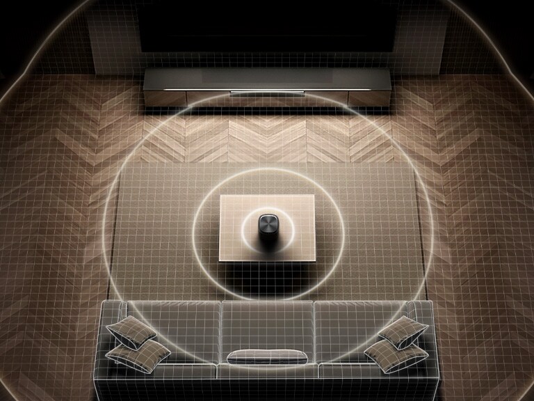 Vue descendante d’un salon avec des ondes sonores circulaires qui se propagent uniformément entre le haut-parleur et la barre de son, illustrant la calibration de la pièce