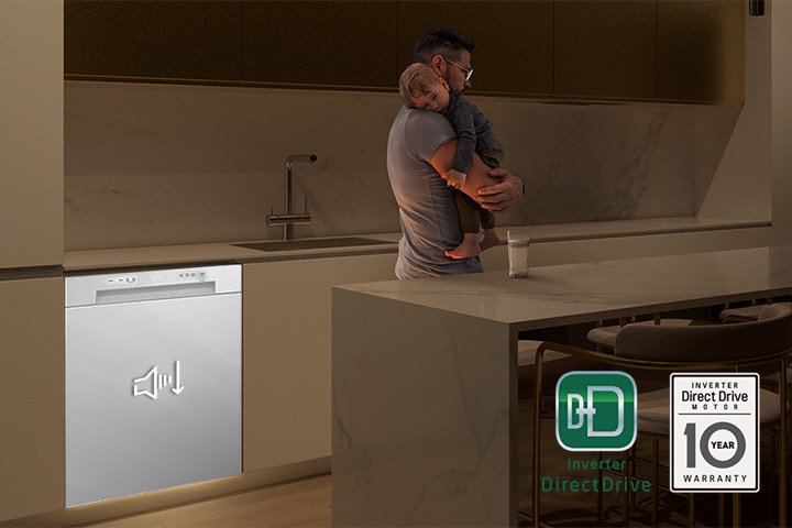 Homme tenant un enfant endormi pendant qu'un lave-vaisselle silencieux fonctionne en arrière-plan