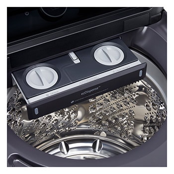  L'ensemble lave-linge et sèche-linge à chargement par le haut LG (WT8600CB) en Noir Acier, illustrant son design haut de gamme intégré harmonieusement dans une buanderie luxueuse avec marbre.