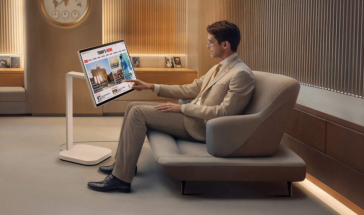 Un homme dans le salon VIP lit les actualités sur un LG Smart Monitor Swing.
