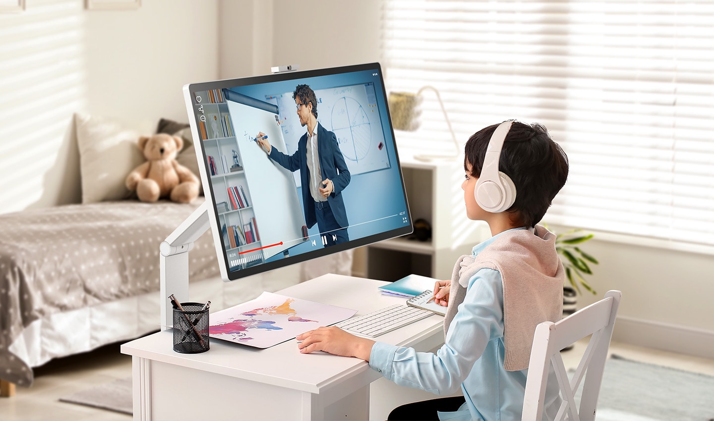 Un enfant regarde un cours en ligne sur un LG Smart Monitor Swing dans une chambre.