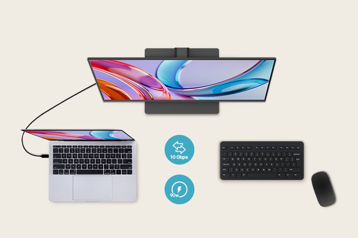 Vue de dessus d’un moniteur connecté à un ordinateur portable, avec un clavier et une souris placés en dessous.