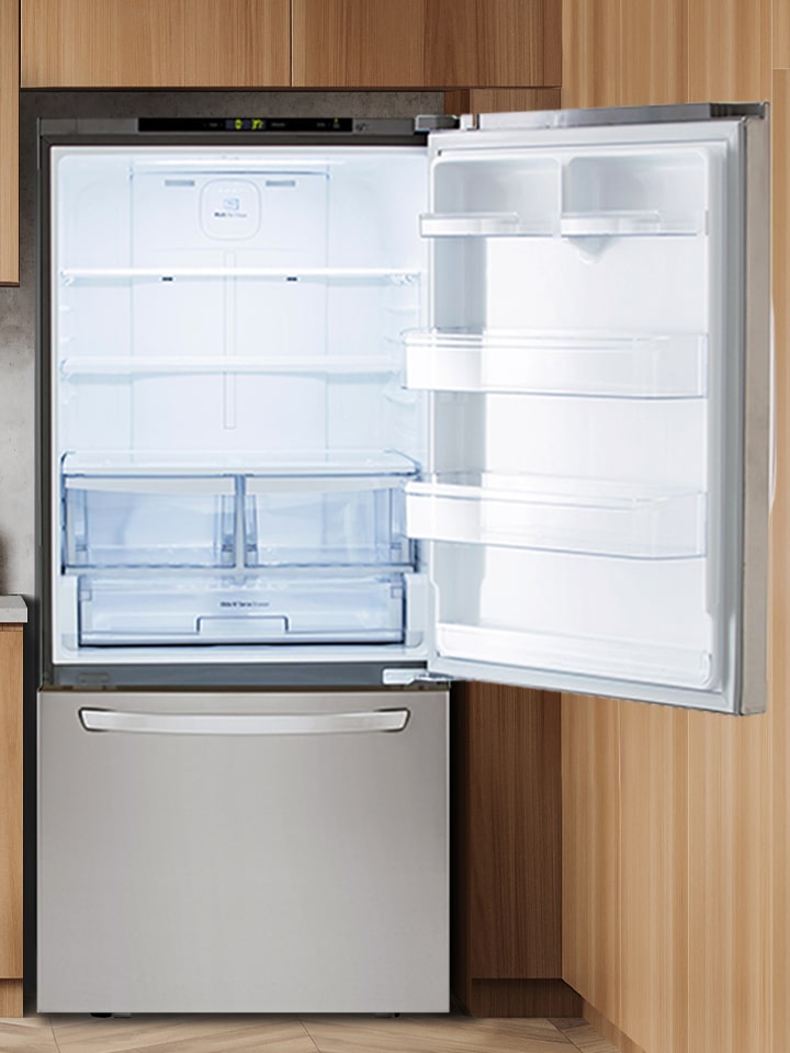 Réfrigérateur à congélateur inférieur LG en acier inoxydable, portes ouvertes révélant un intérieur spacieux et éclairé.