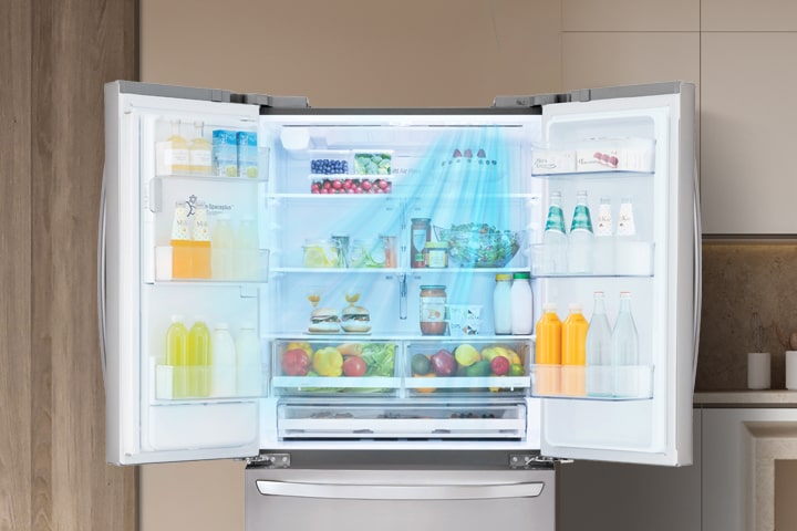 Intérieur d'un réfrigérateur LG en acier inoxydable avec étagères remplies et système de ventilation Door Cooling.