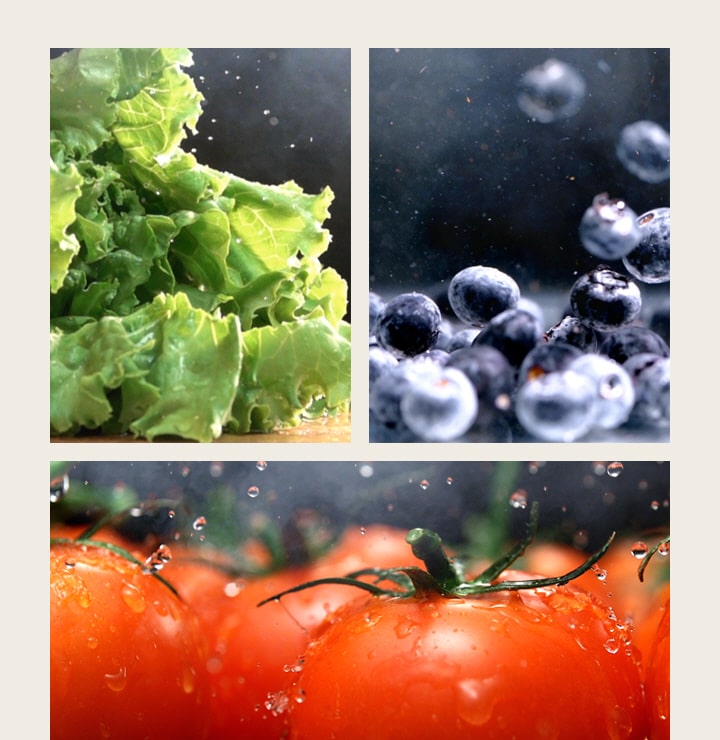 Laitue verte à gauche, bleuets au centre et tomates rouges en bas avec des gouttes d'eau.