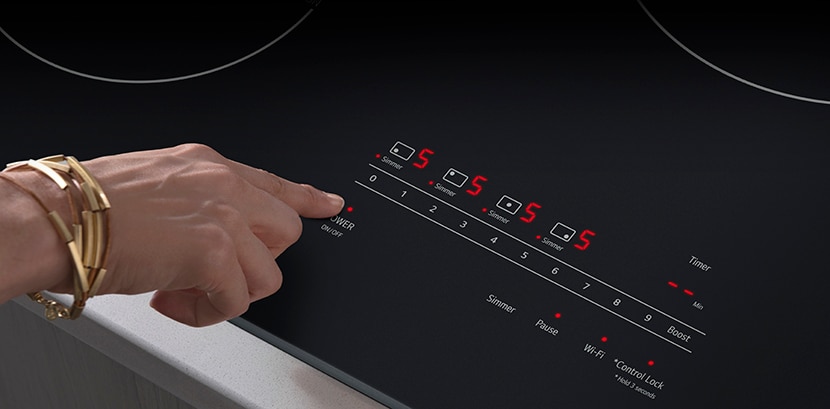 Gros plan d’une main réglant les paramètres de la surface de cuisson à induction de LG à l’aide des commandes tactiles en verre SmoothTouchMD, démontrant un fonctionnement intuitif et tactile pour un contrôle facile de la température.