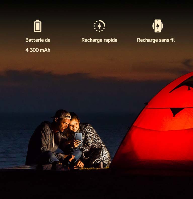 Un couple devant la tente, la nuit.