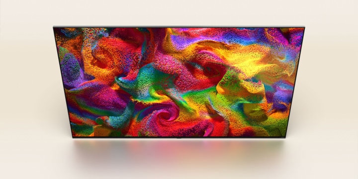 Des particules de couleur éclatent sur l’écran, puis les pixels se transforment lentement en un gros plan d’un mur peint avec un motif coloré sur l’écran du téléviseur de LG.