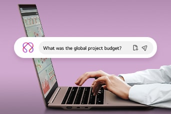 Cette image montre des mains tapant sur un ordinateur portable avec une barre de recherche affichant la question : « Quel était le budget mondial du projet? »	
