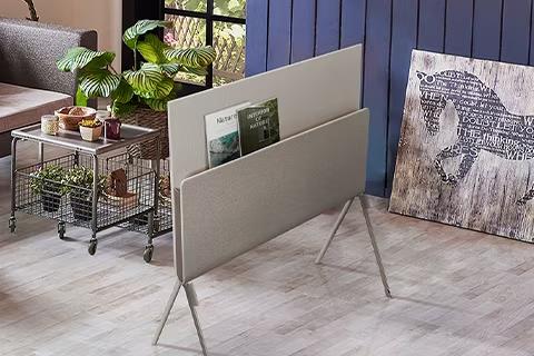 Posé vu de dos avec des magazines sur la nature placés sur l'étagère dans un salon à thème végétal.