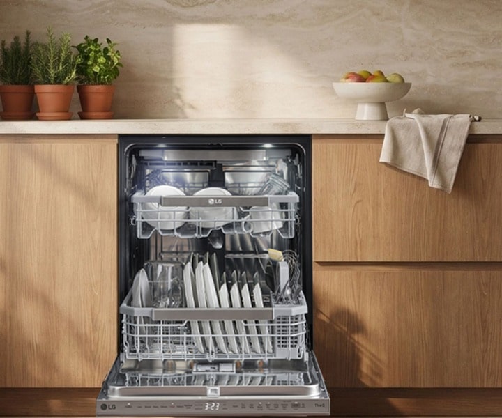 Lave-vaisselle LG ouvert montrant un intérieur spacieux avec les paniers supérieur et inférieur chargés