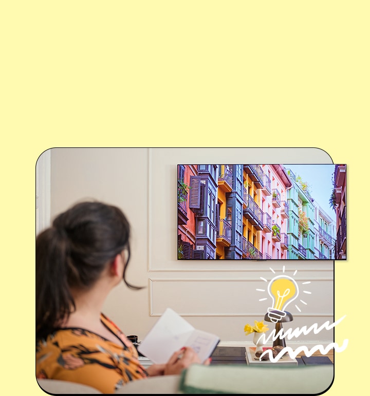 La femme regarde la télévision avec un cahier.